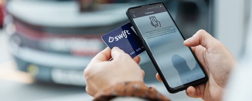 A  person holding their swift card against their phone. The collector application is open on the phone.