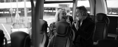 Two friends laughing on the bus